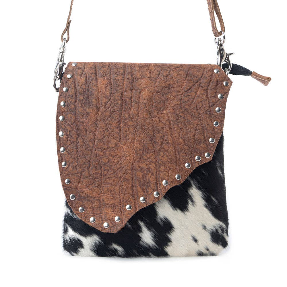 Stonebrook Canvas & Hairon Crossbody Bag in Spotted Ivory featuring genuine hair-on cowhide, textured leather, decorative silver studs, and an adjustable crossbody strap.
