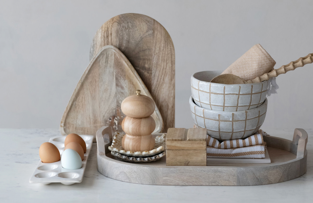 Stoneware egg holder displayed on a kitchen countertop with fresh eggs and natural kitchen accessories.