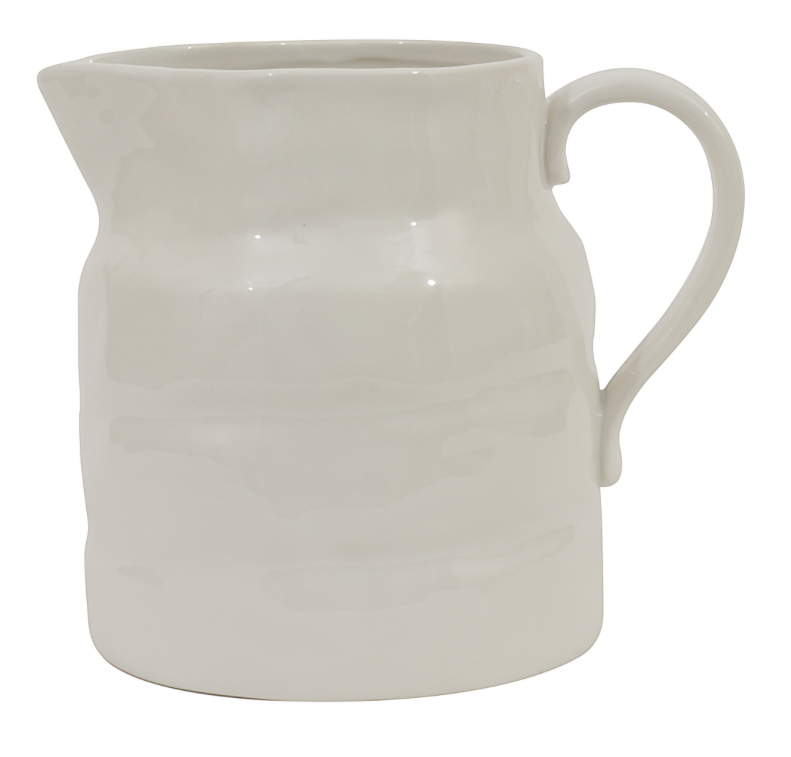White stoneware vintage style pitcher with ripple texture and uniquely shaped pouring spout.