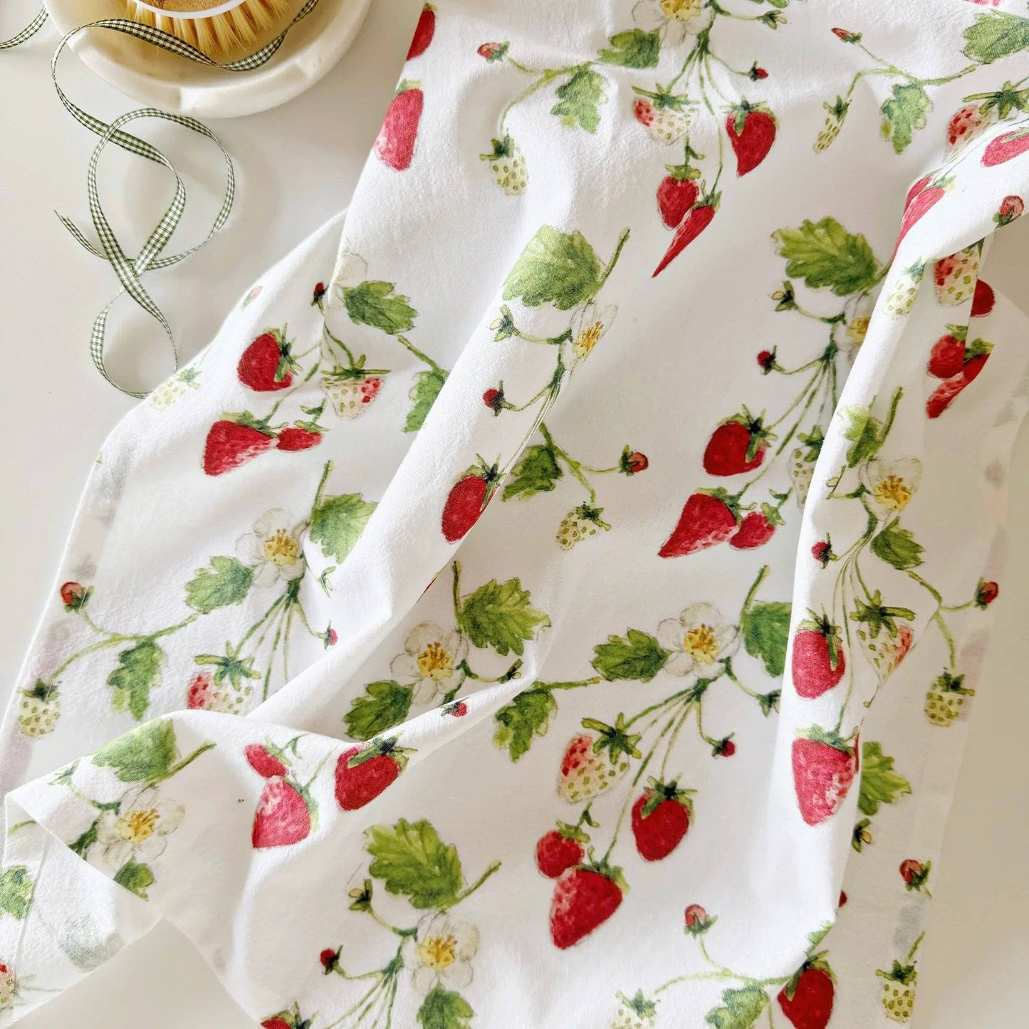 Whimsical strawberry watercolor illustrations printed on a soft cotton flour sack tea towel.