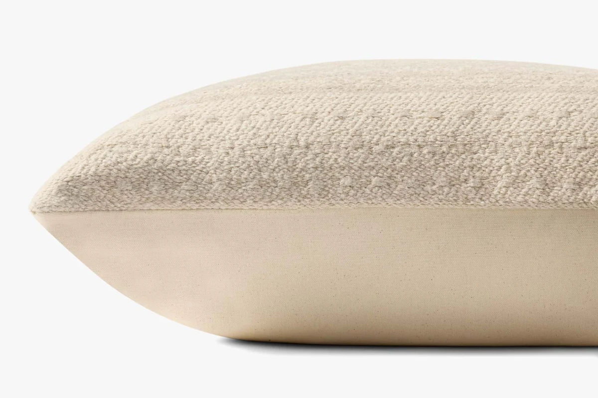 Close-up of the natural textured pillow highlighting the jacquard woven fabric, knife-edge finish, and hidden zipper with antique bronze Loloi logo pull.