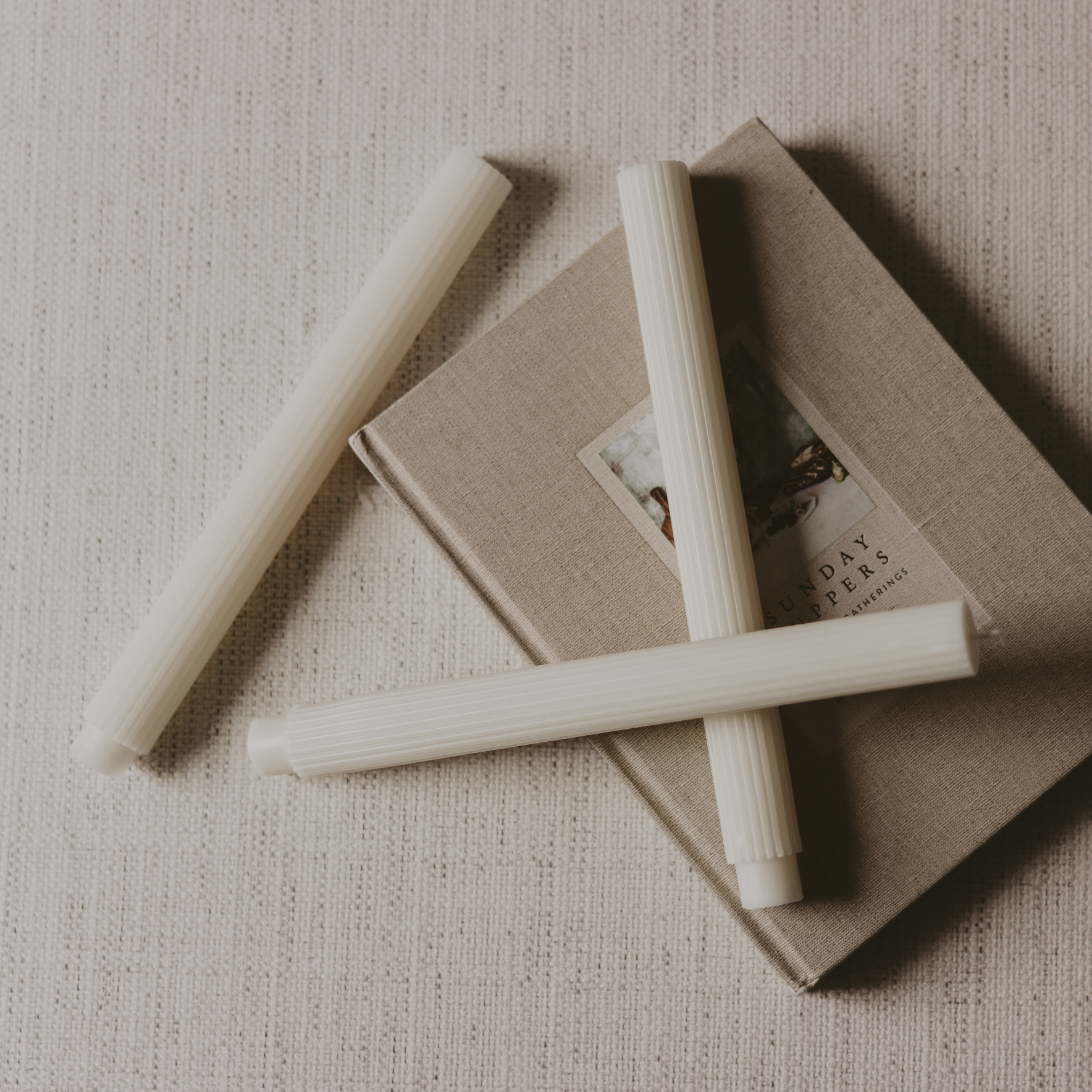 Set of three white fluted taper candles with a sculptural design for timeless home décor.