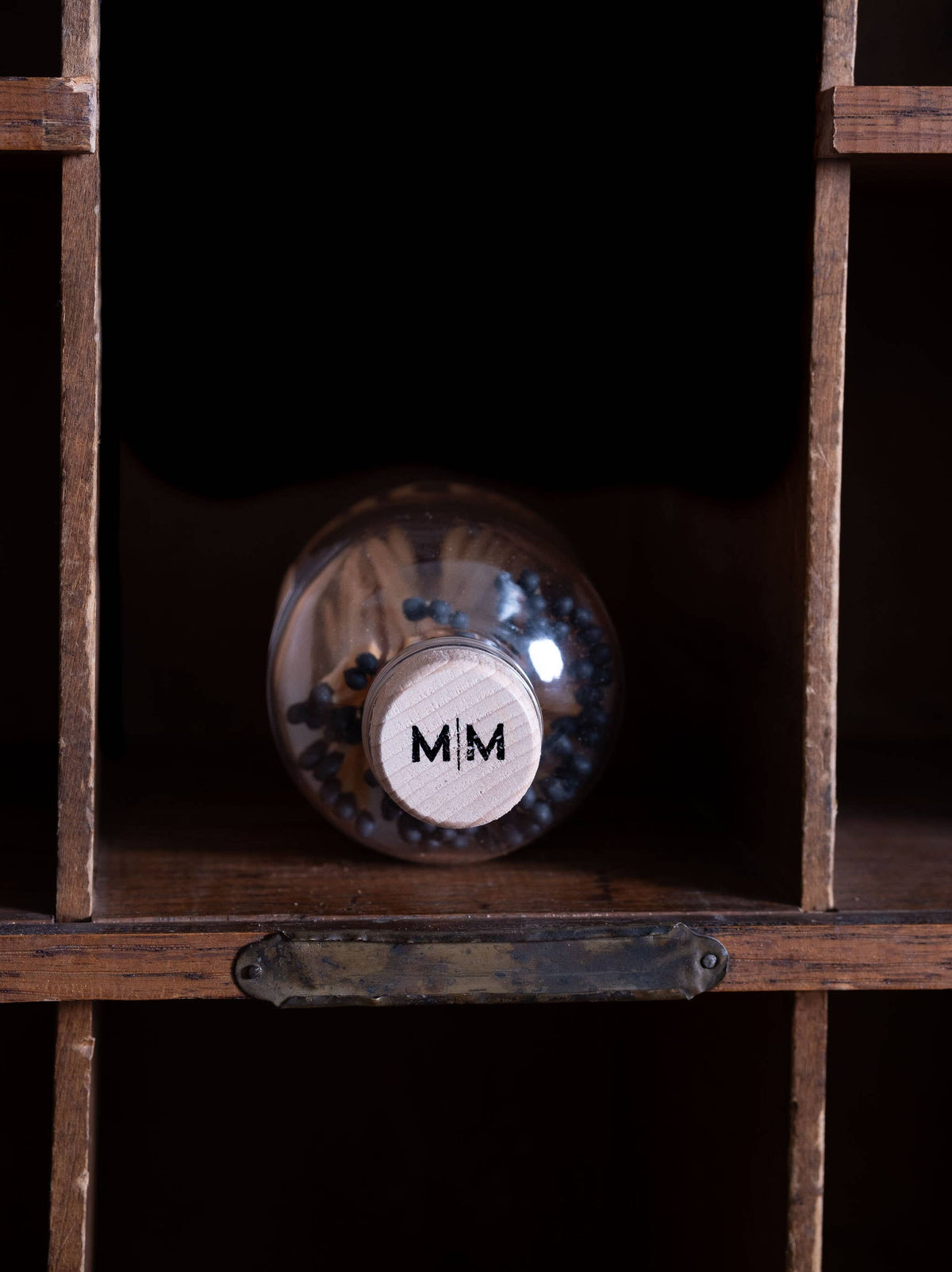 Detail of the wooden cork closure with stamped logo on the apothecary match jar.