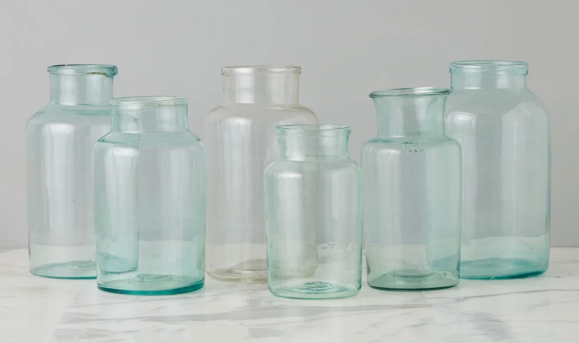 Set of clear glass jars on a light gray background