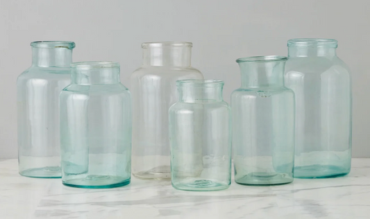 Set of clear glass jars on a light gray background