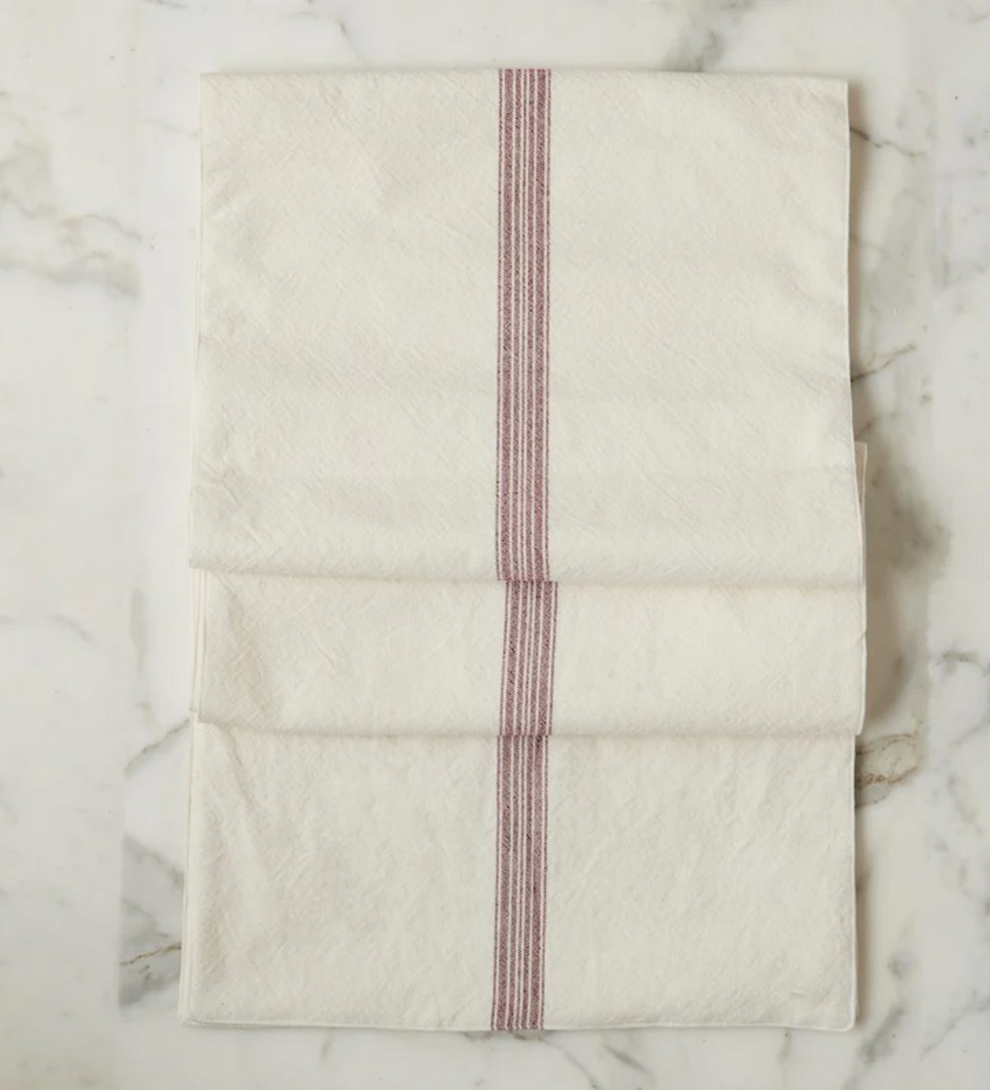 Folded fabric with red stripes on a marble surface
