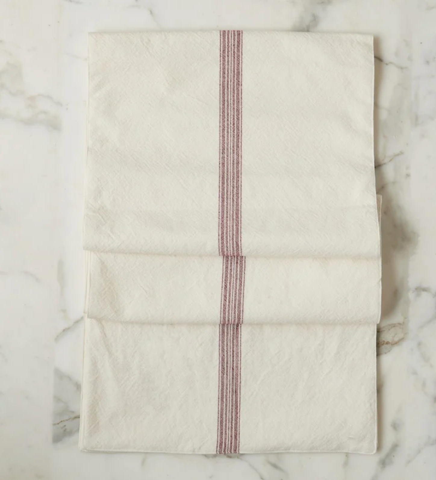 Folded fabric with red stripes on a marble surface