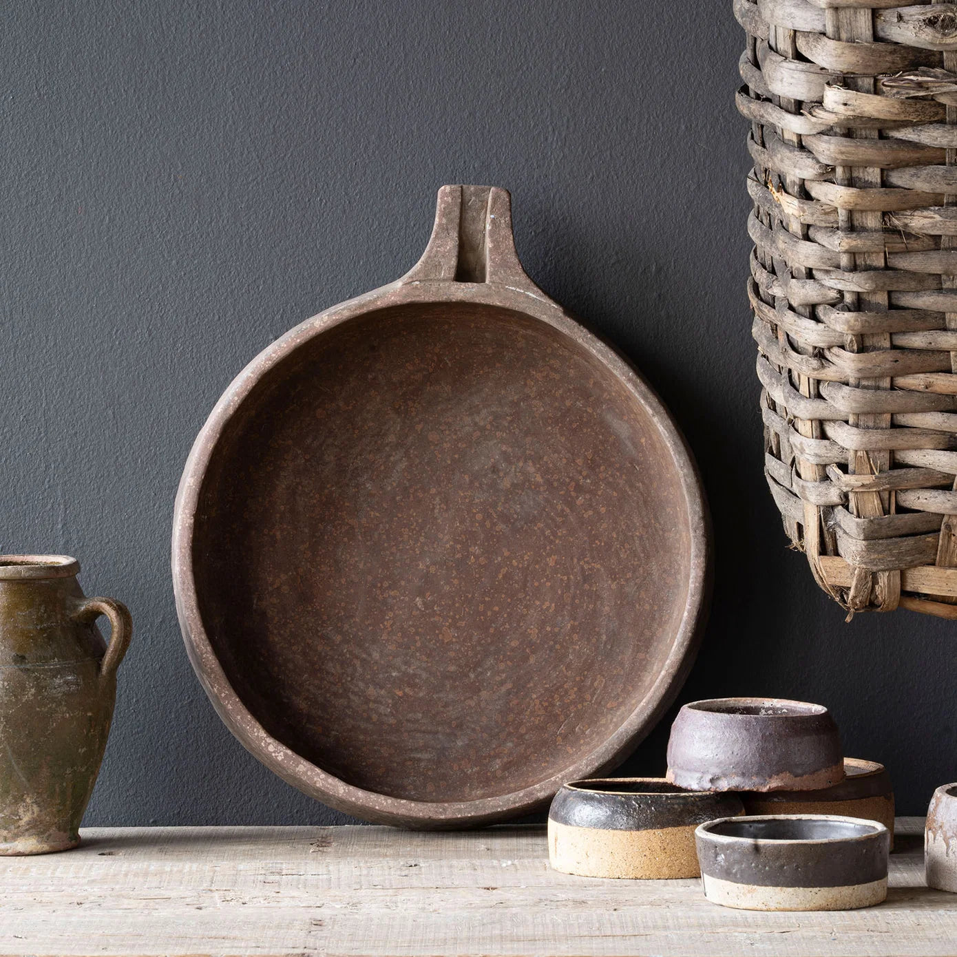 Vintage Stone Kundi bowl carved from sandstone in India with a shallow round form, small spout, and naturally aged patina.