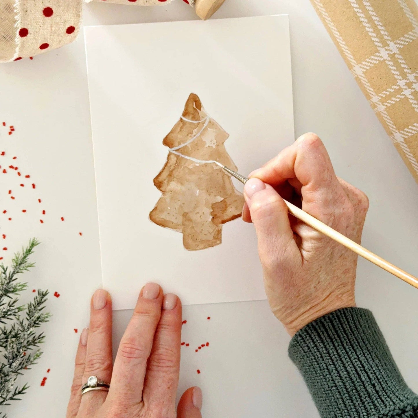 Close-up of watercolor-ready Christmas notecards featuring festive gingerbread and holiday illustrations printed on premium watercolor paper.
