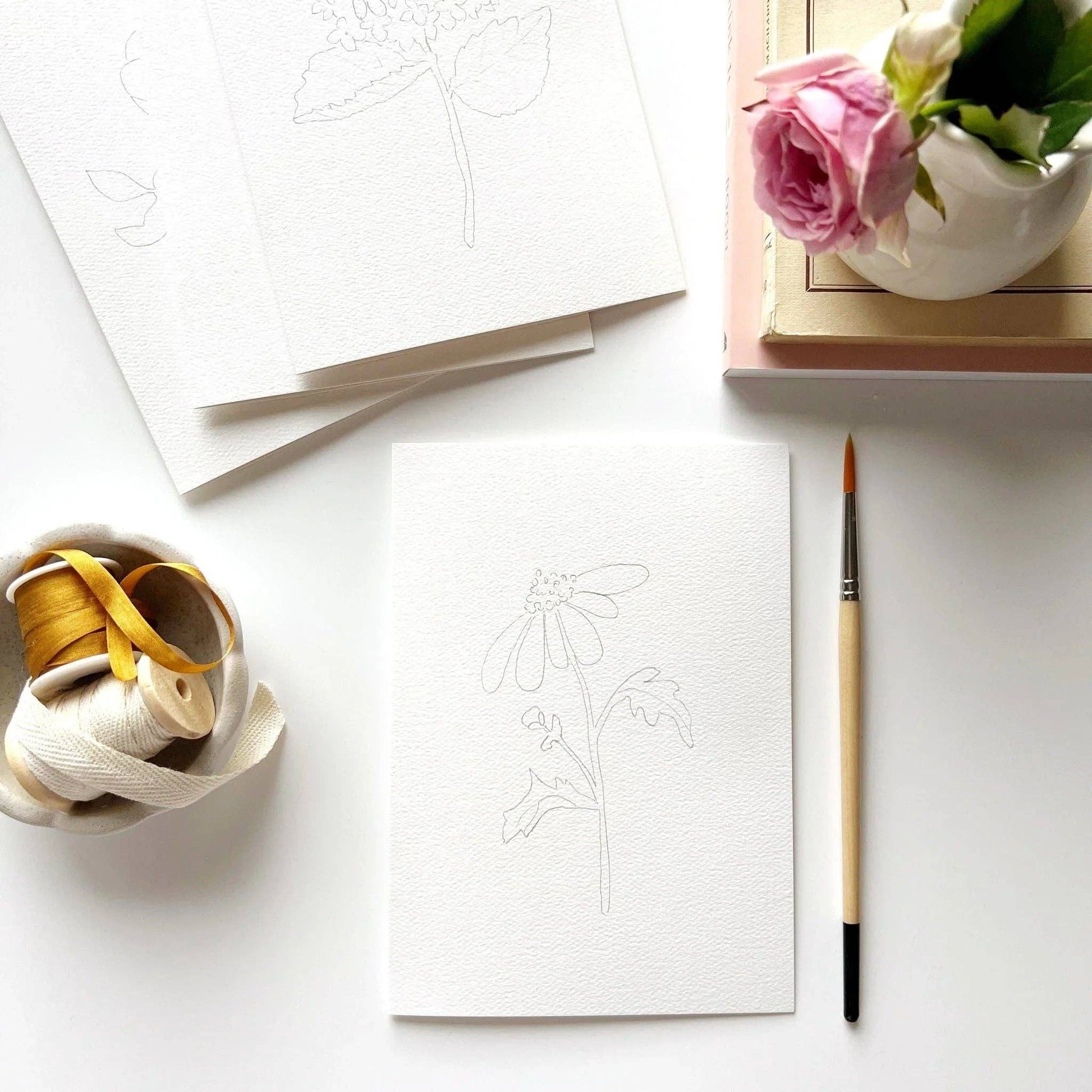 Garden flower paintable notecard set styled with watercolor supplies and botanical stationery.