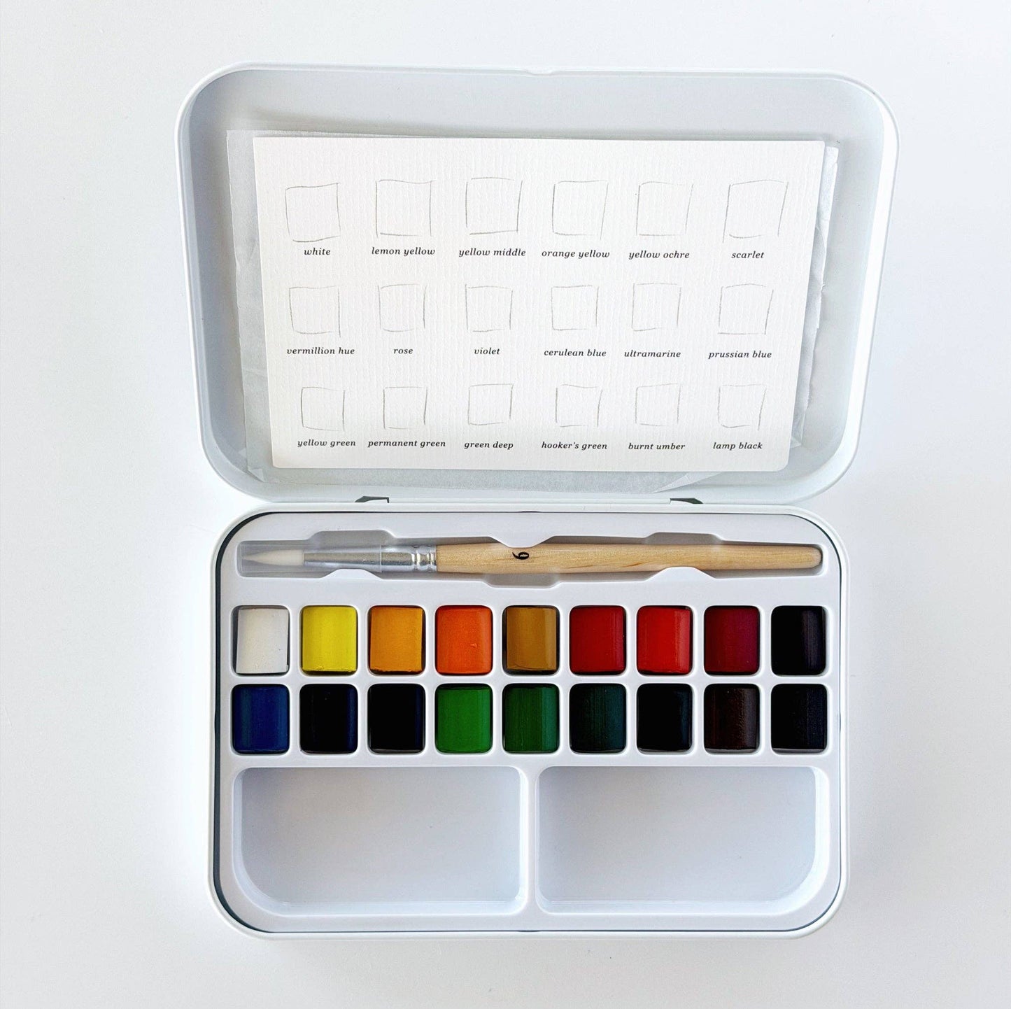 Emily Lex Watercolor Paint Set featuring 18 watercolor paints, a fold-open metal tin with mixing trays, and a petite size 6 round brush.
