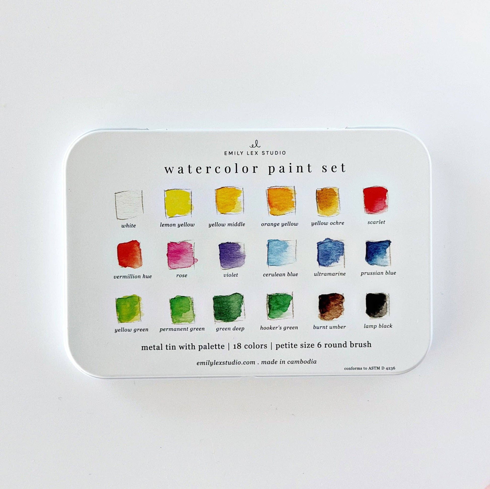 Emily Lex Watercolor Paint Set featuring 18 watercolor paints, a fold-open metal tin with mixing trays, and a petite size 6 round brush.