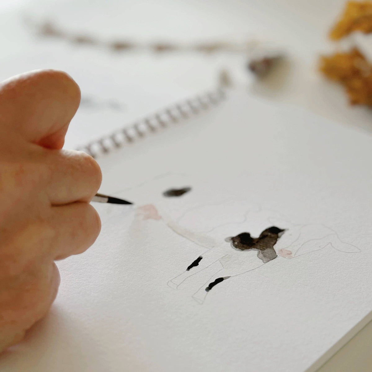 Open watercolor workbook displaying farm-themed illustrations on premium watercolor paper with easy-to-follow painting guidance.