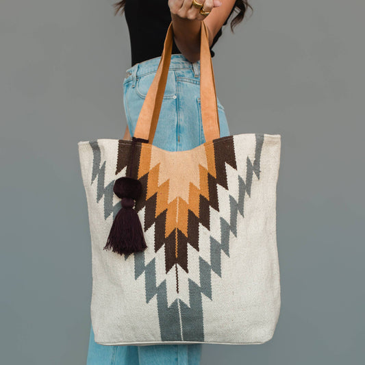 Western geometric cotton tote bag in white, gray, and camel with contrasting tan shoulder straps and a coordinating tassel.