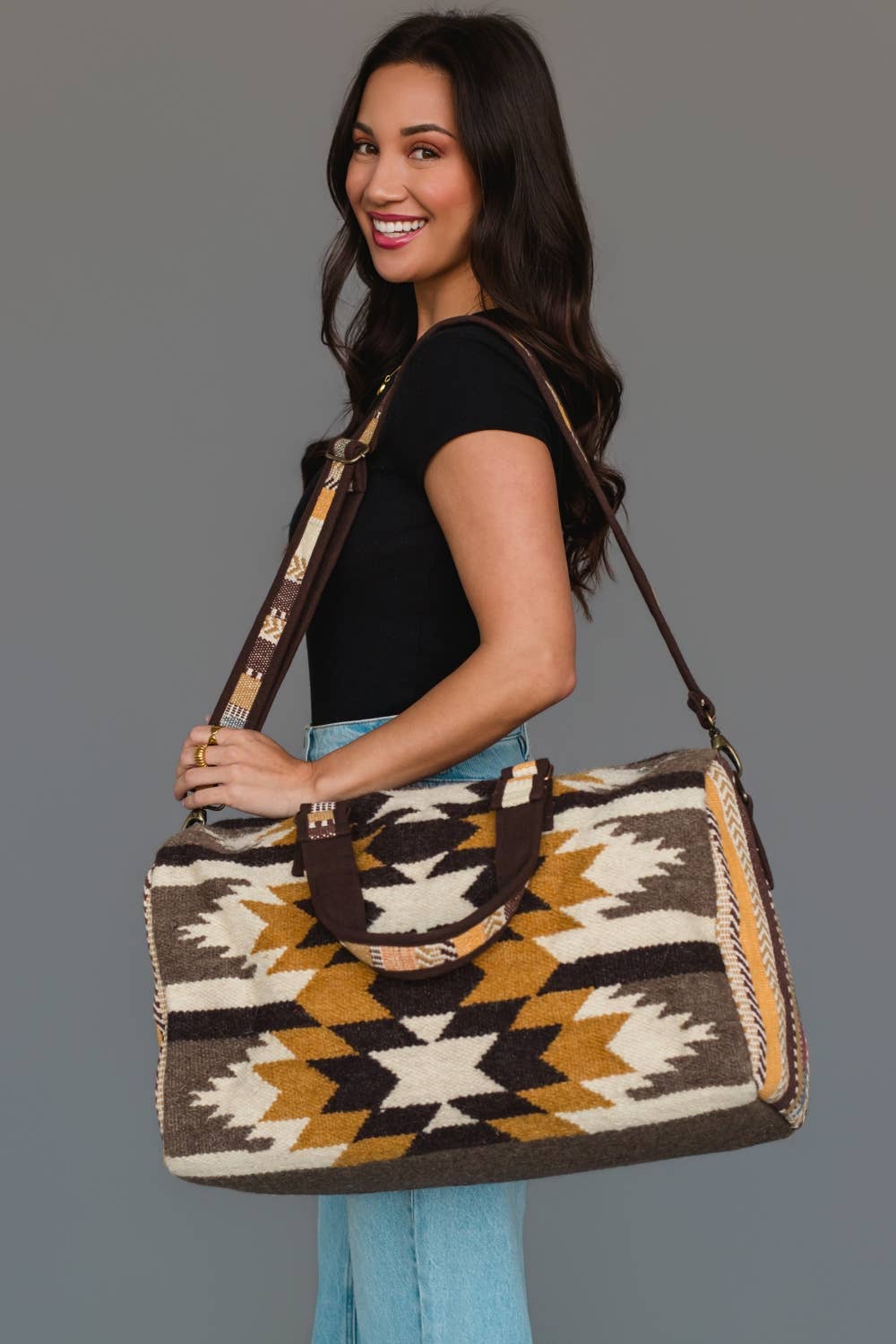Detail of the adjustable shoulder strap and carrying handles on the Western geometric duffel bag.