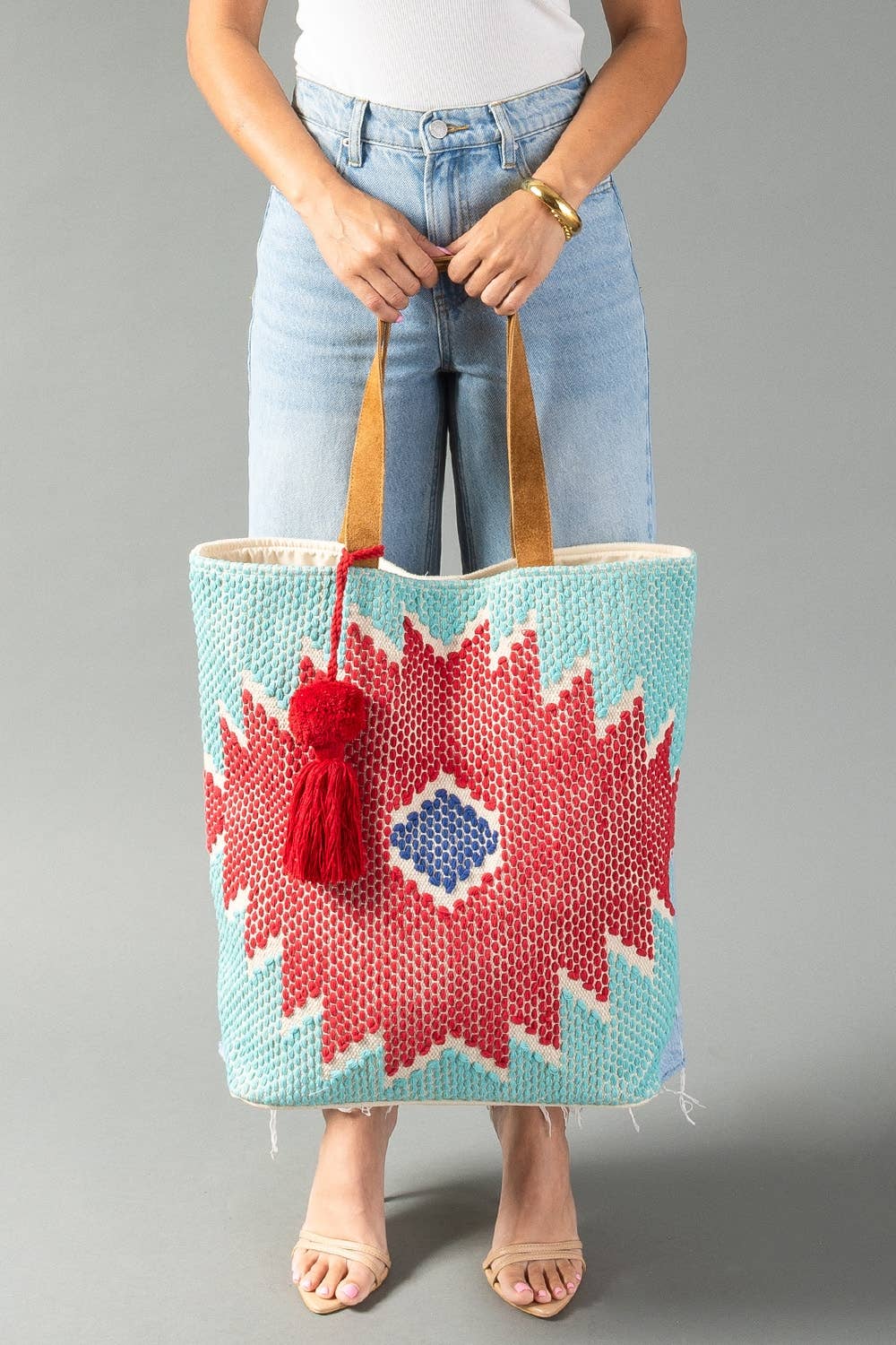 Front view of woven Western tote featuring a bold geometric pattern in red, turquoise, and blue.