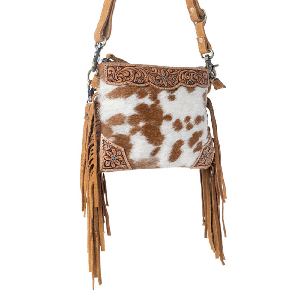 Bourbon Trail Handtooled Hairon Crossbody Bag featuring genuine leather, handtooled detailing, natural brown and white cowhide, and flowing Western fringe.