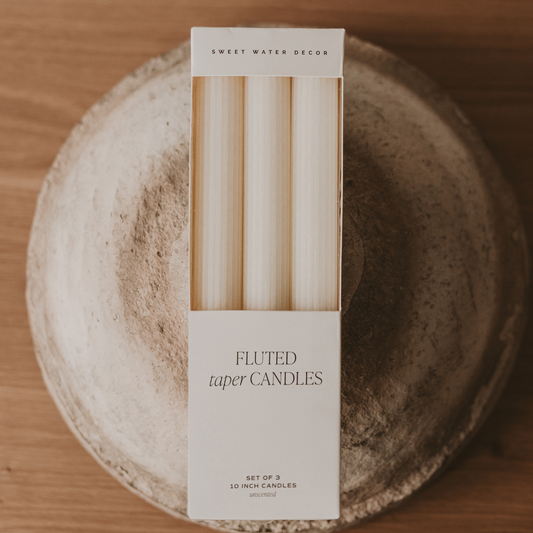 Set of three white fluted taper candles with a sculptural design for timeless home décor.