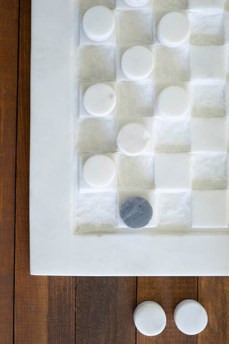 Natural marble checkerboard with contrasting checker pieces.