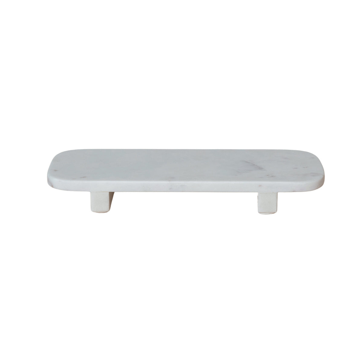 White marble pedestal tray with a long rectangular shape, petite feet, and naturally varied stone veining.