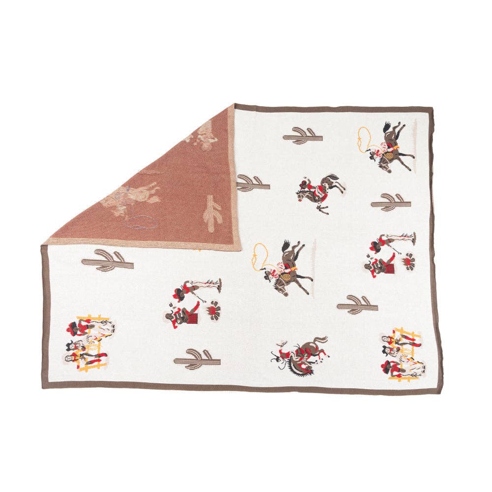 Woven cotton throw blanket featuring classic cowboy scenes and Southwestern-inspired patterns in burgundy, cream, black, and brown.