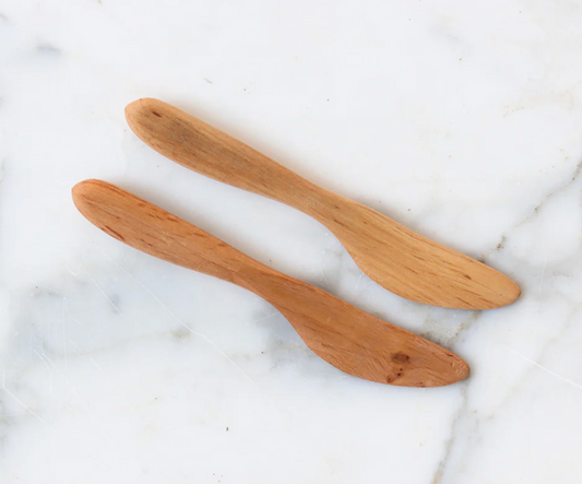 Two wooden spoons on a marble surface