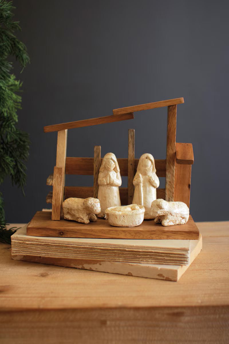 Wooden nativity set featuring handcrafted paper mache figures in a rustic wooden stable.